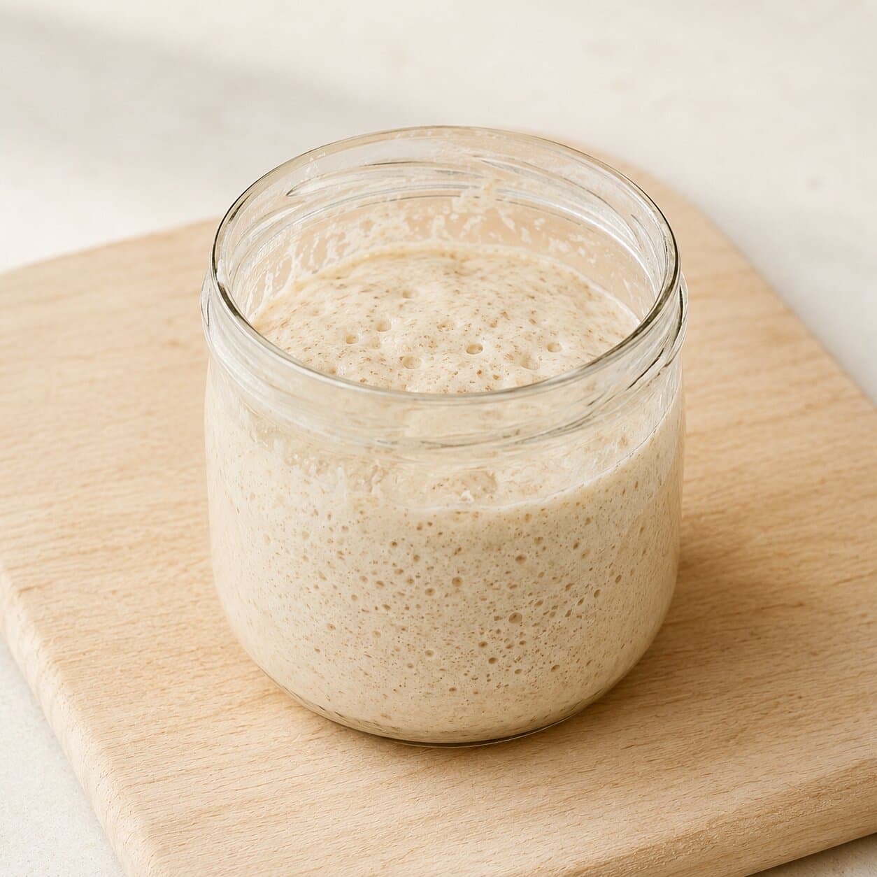 Glass jar of bubbly sourdough starter